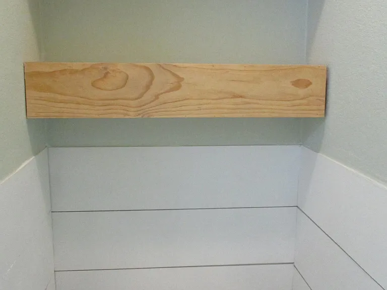 water closet in master bath with built in shelves and shiplap wainscoting