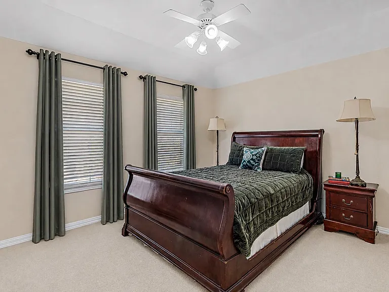 Carpeted room featuring a tray ceiling and a ceiling fan with integrated lighting