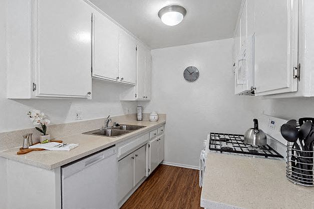 Upgraded kitchen with plank flooring and kitchen appliances which includes a gas range, dishwasher, and a built-in microwave at the Ridgeview Apartment in Northridge