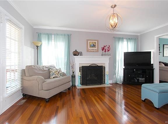 The Family Room focal point is the Gas Fire Place and features Crown Molding, Wainscoting and Brazilian Walnut Hardwood Flooring. The French Door leads to great Rear Decking.