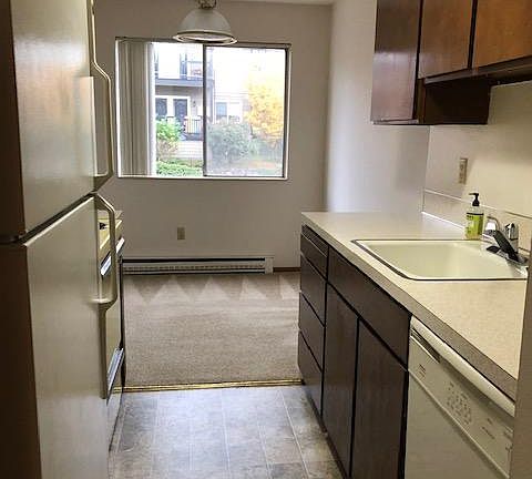 Walk thru kitchen with full size refrigerator and range with oven.