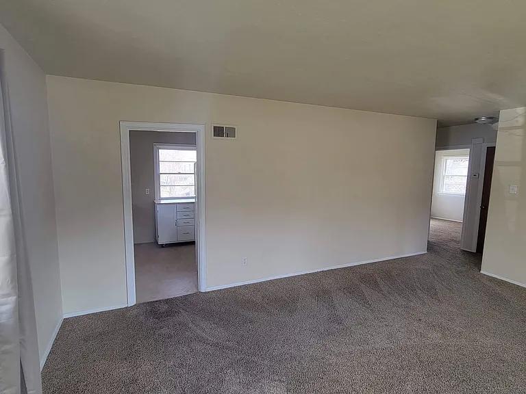 Living room - kitchen entry on left and entrance to bathroom and bedrooms on right