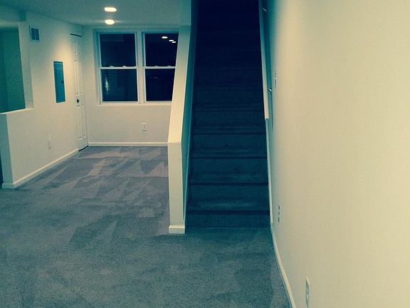 standing in kitchen and facing living room and stairs to 3rd floor bedroom (more living room space behind the stairs as well as coat closest)