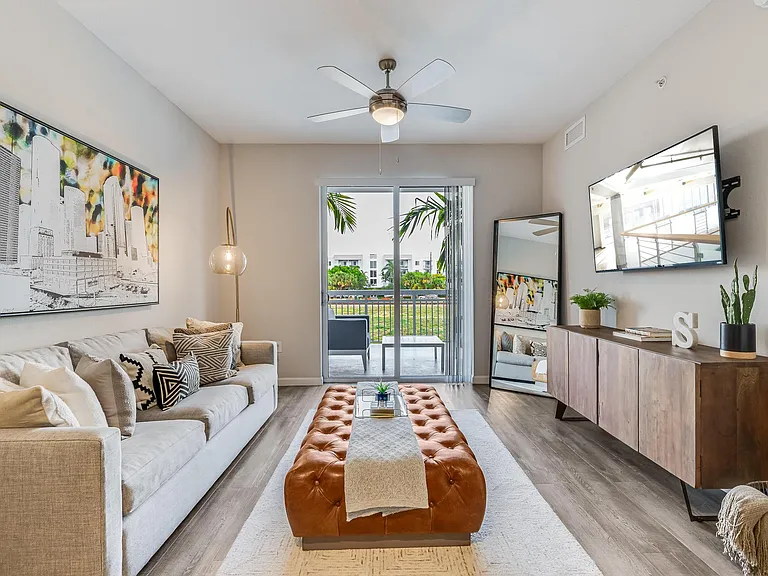 Living Room with Wall-Mounted TV, Balcony View, and Ceiling Fan