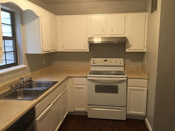 Kitchen with electric stove and gas hot water heater.