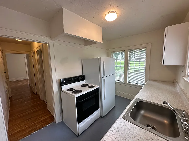 kitchen from back exit doorway. There is room beside the fridge for a large kitchen cart or even a small bistro.