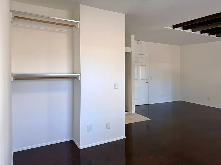 Bedroom area with additional storage space/open closet.