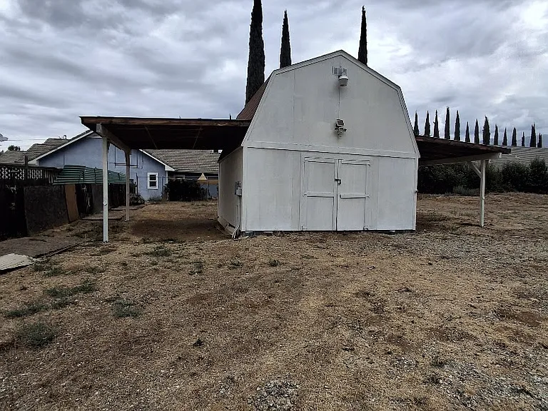 picture of small barn with carports in yard area