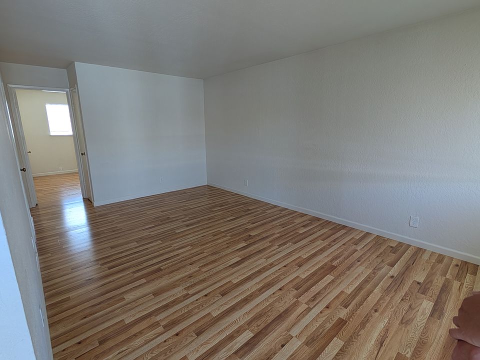 Living room, right side of kitchen separated by a wall