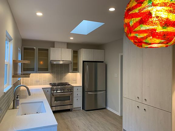 Newly renovated kitchen with pantry cabinet on the right and eating area in foregound