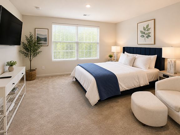 Relax in the spacious primary suite featuring a plush king bed, 55-inch 4K Smart TV, luxurious accent chair with ottoman, walk-in closet, and a private en-suite bathroom_designed for comfort and a restful stay.
