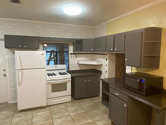 Gas range, full-sized refrigerator, microwave and tons of kitchen storage! Exposed brick wall.