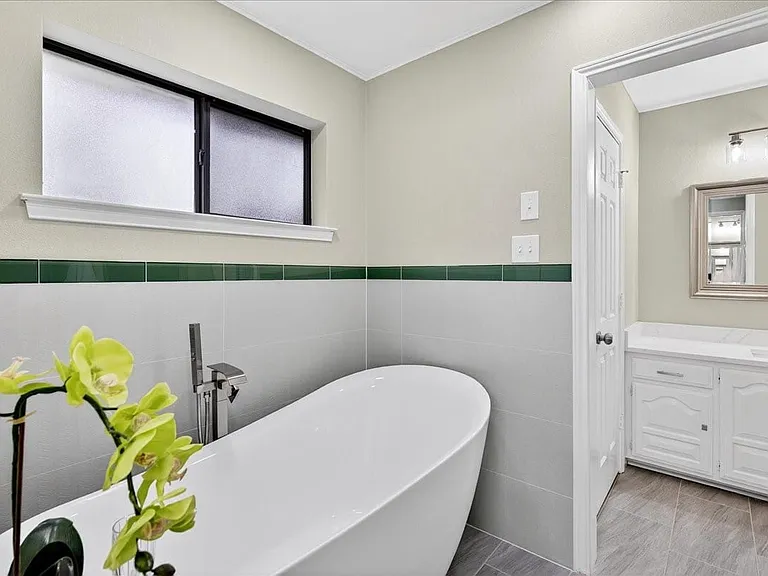 Separate soaking tub and walk in shower opens up to two vanities and closets on either side.