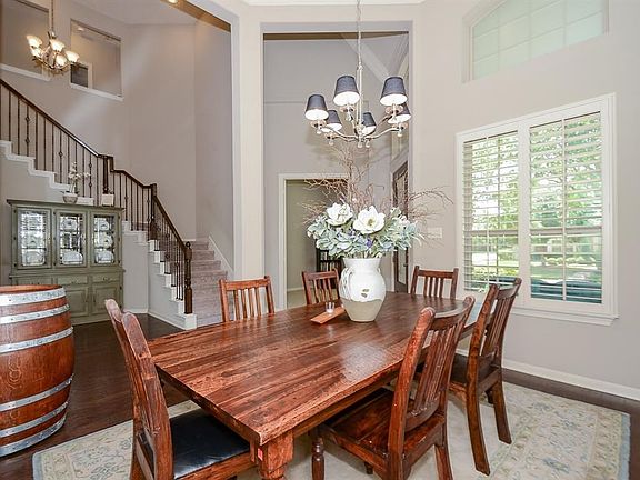 Formal dining room with high ceilings, and a wall of window providing abundant natural lighting. The plantation shutters are a plus! Beautiful hardwood flooring.