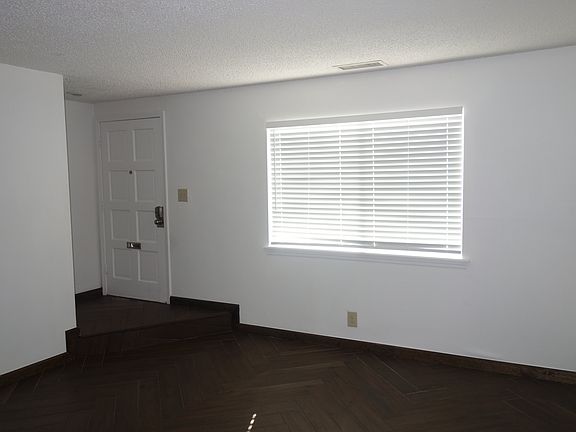 Front entry door leads to the living room with woodlook tile floor in a herringbone pattern!