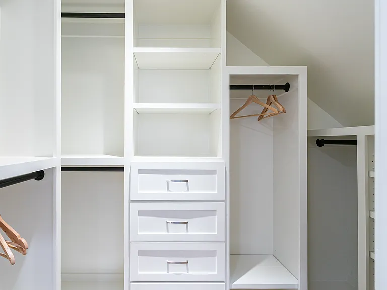 Full walk in closet with shelves, area to hang clothes, and hamper