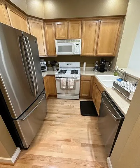 Kitchen with tall breakfast counter, dishwasher, microwave, refrigerator, and gas stove and oven