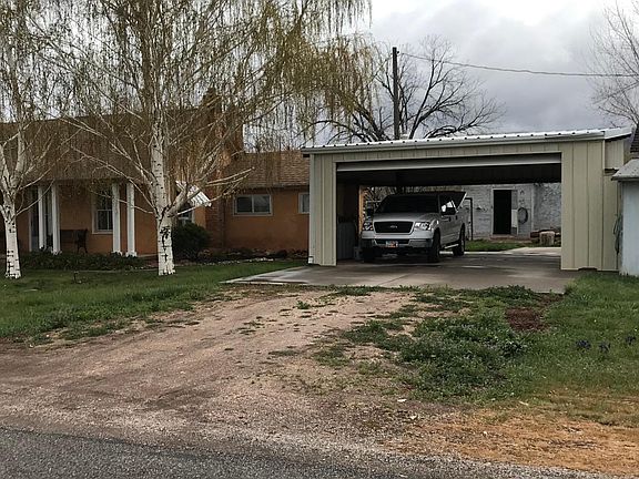 West side of property showing spacious garage/carport, remote garage door opener included.