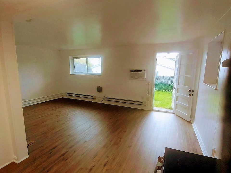 12x20 Open Living room/bedroom area with lots of natural light from 2 windows, new floors and door/screen door to 20x25 private backyard/outdoor living space, Wall AC, Separate Wall and baseboard heat