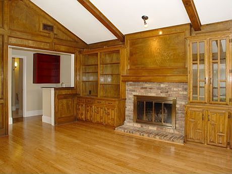 Family room has a pool view,paneled walls, bamboo floors,brick woodburning fir