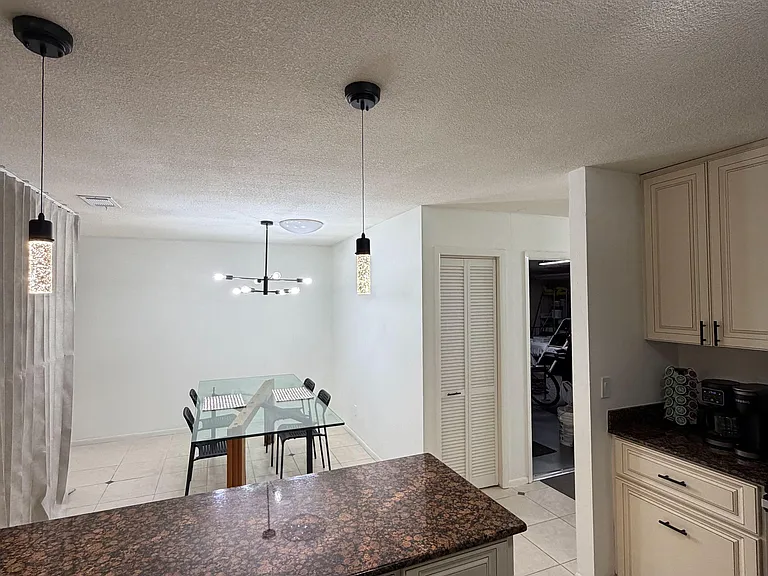 Open kitchen with a large island and generous cabinetry, flowing into a dedicated dining area for everyday meals.