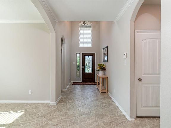 A 2-story entry is flooded by natural light through the door, sidelight and window perched above providing a welcoming glow.