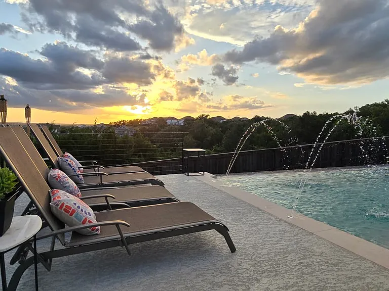 Travertine deck, spa, lounge space - resort living at home.