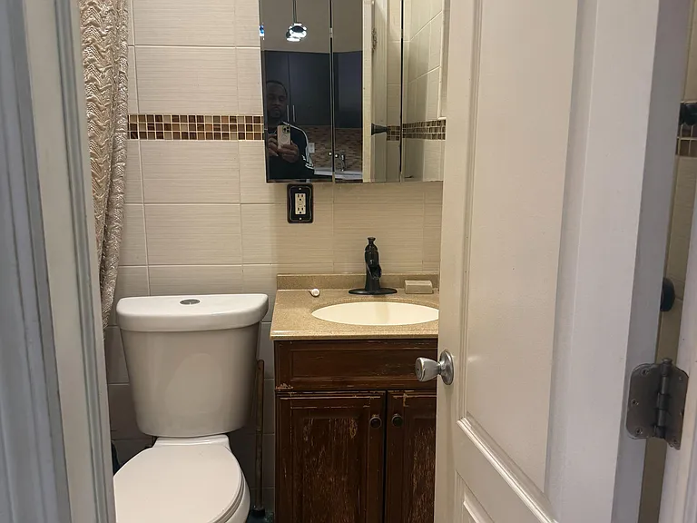 Full bath with shower/tub combo, tile surround, and convenient fixtures for everyday use + window for ventilation & light.