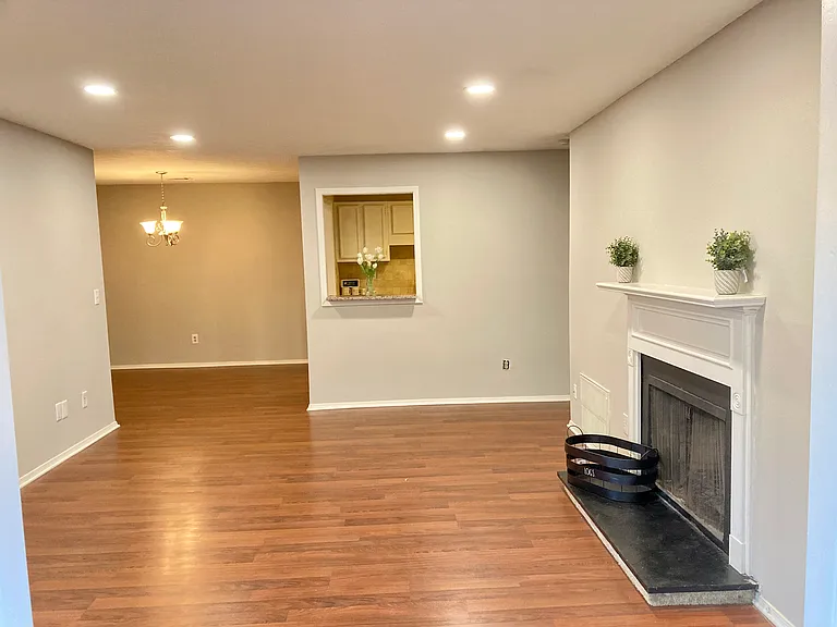 Living room with gas fireplace and LVP floor. connected to the dinning area and kitchen