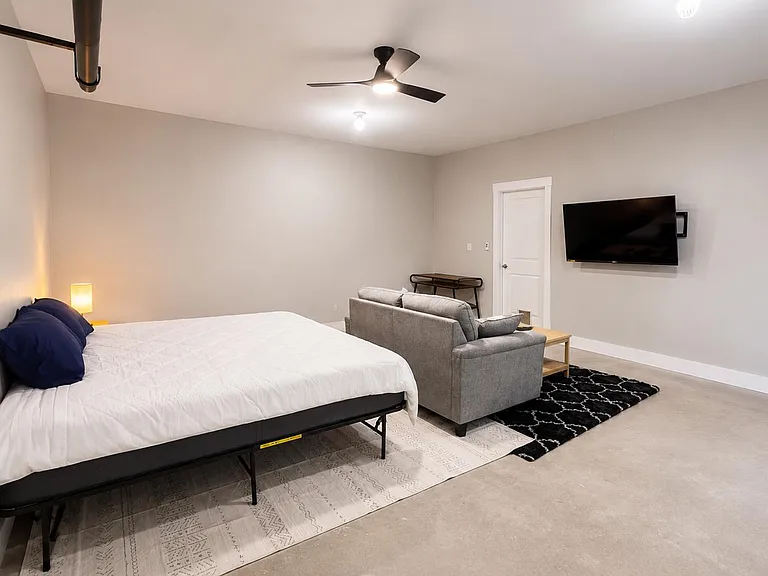 A king sized bed, 50 inch TV, and a couch. This room was designed to be as comfortable as possible.