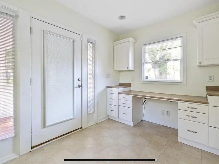 Spacious laundry room with lots of storage space and potential additional office space with a desk.