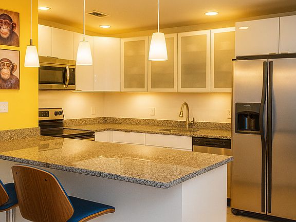 Kitchen with dishwashing machine, oven, stovetop, refrigerator.