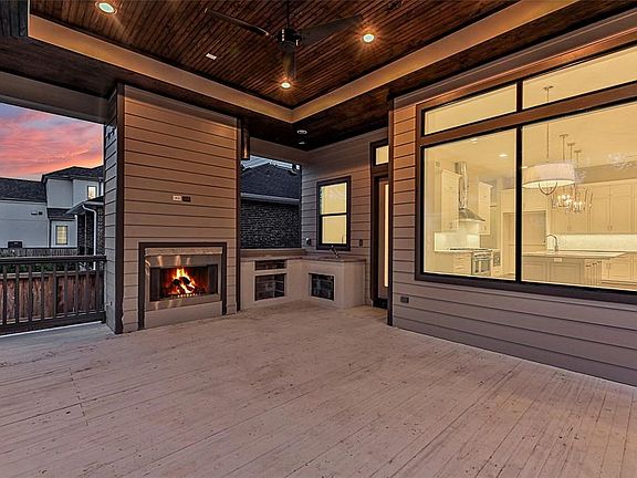 The massive outdoor patio is wired for a TV mount, speakers, and includes a fireplace, sink, and grill. Grill to be installed soon.