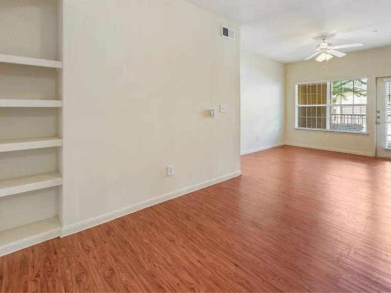 Large open living area with plenty of natural lighting and beautiful flooring at Stonehaven Apartments in Houston, TX