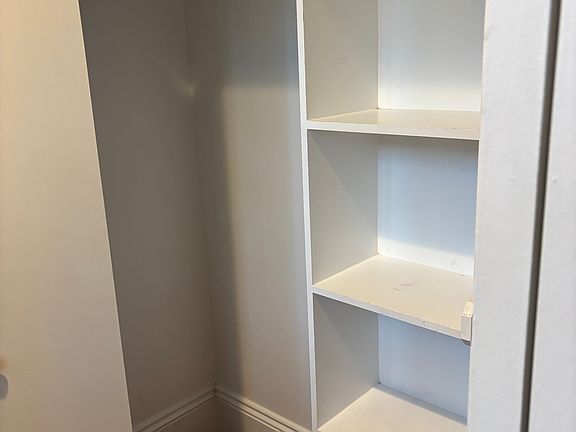Nice sized closet with bifold doors and shelving in the 'dressing' area.