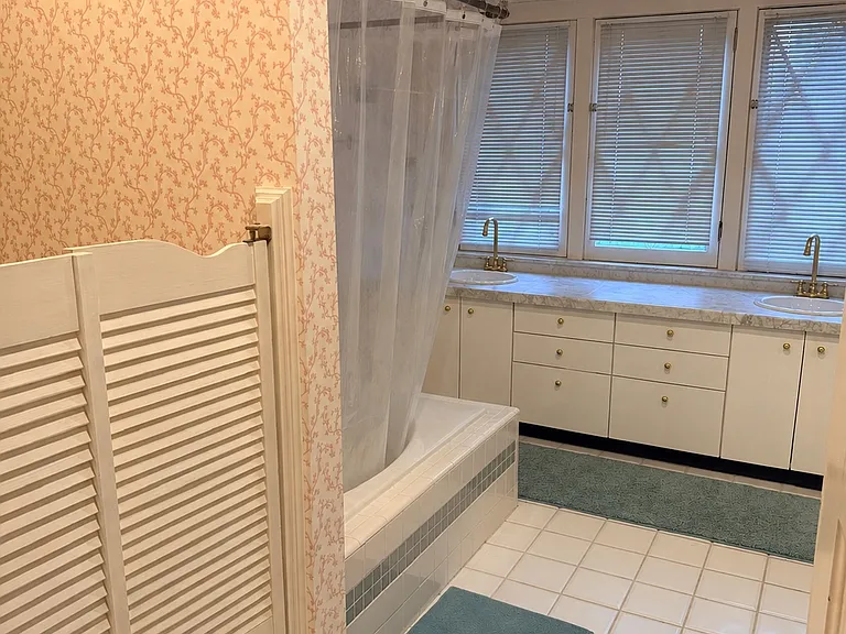 Bathroom with double vanity, tub/shower area.
