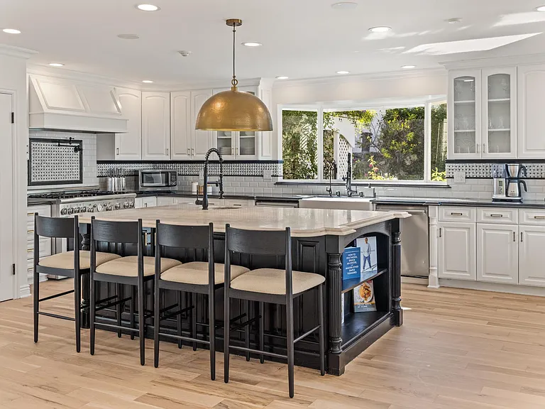 A spacious kitchen, complemented by 4 additional bar stools.