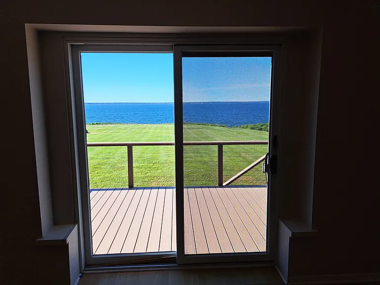 Primary bedroom sliding door to deck and lakeview