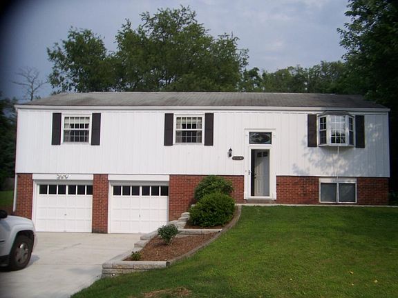 Basketball pole in driveway. One garage bay has automatic door, keypad entry.