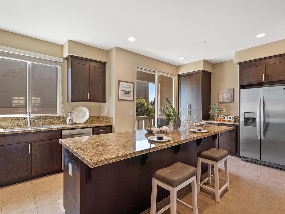 Kitchen with SS appliances and granite top island with plentiful storage areas.