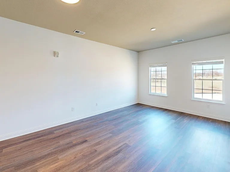 The spacious living room in The Pyle floor plan features wood-style flooring and two large windows that offer natural light. The spacious living room in The Pyle floor plan features wood-style flooring and two large windows that offer natural light.