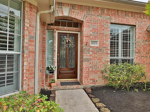 Arched entry with brick porch and mahogany door with lead glass insert. Sidelight and transom windows for loads of natural light.
