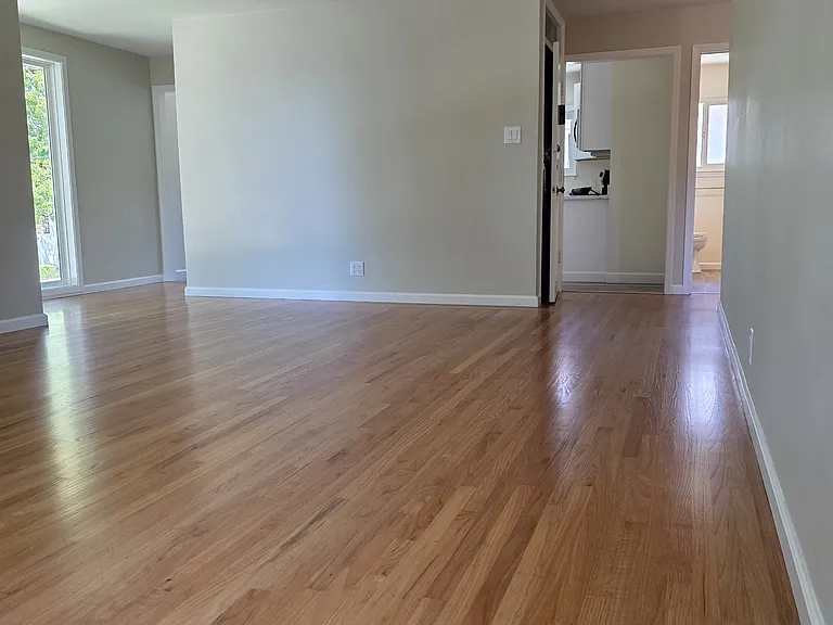 Large living room with hardwood floors. View looking from farthest corner away from front door.