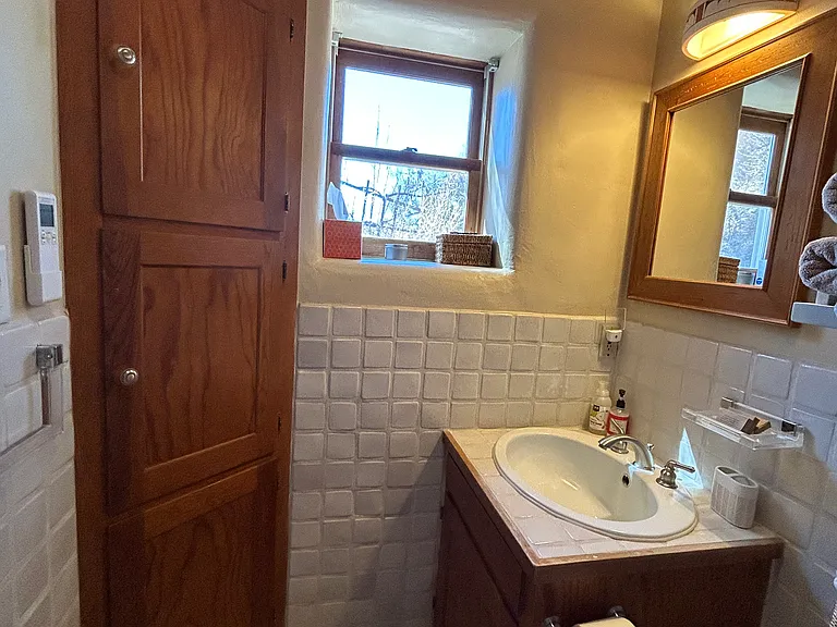 View of bathroom vanity and corner storage.