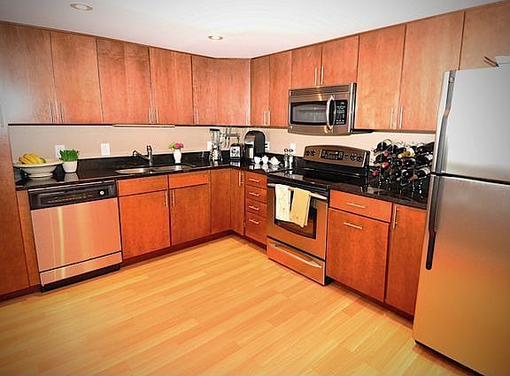 Kitchen with granite counters, undermounted sink, stainless steel applianes.