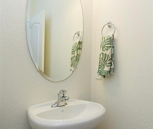 The half bathroom located on the first floor is spacious and has ceramic tile flooring and a nice pedestal sink.