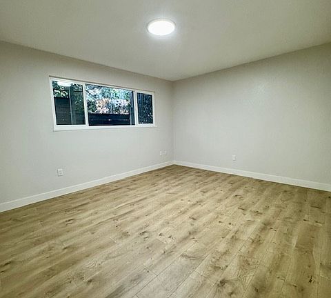 Bedroom 2 with large closet and recessed lighting. New wood flooring. New windows.