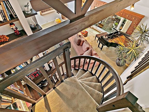 A spiral staircase in the living room takes you up to a large loft. Built-in shelves nestle around t