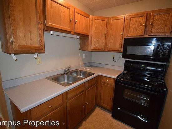 Kitchen with appliances. Vaulted wooden ceiling upstairs.