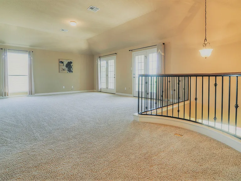 Upstairs game/flex living room is huge and has french doors that open to a balcony. This whole area will be upgraded to brand new wide Luxury Vinyl plank